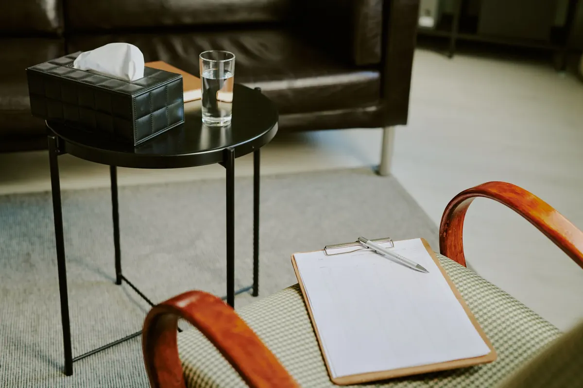 Calm counselling room with clipboard and side table