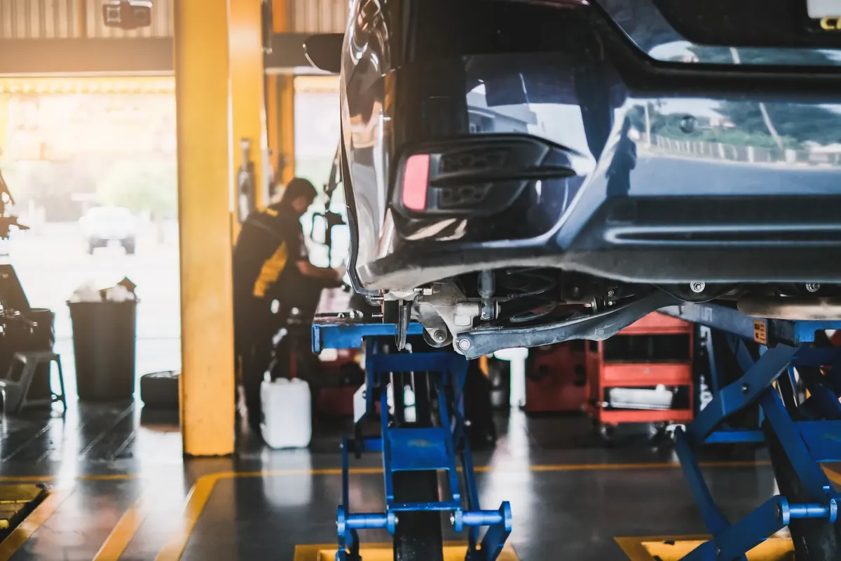 Car raised on a lift in a vehicle workshop for service