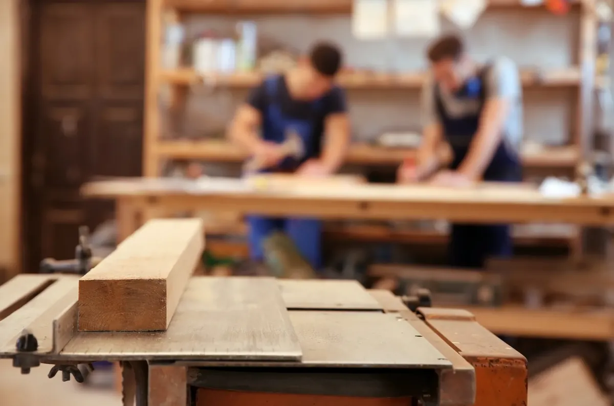 Workbench in a carpentry workshop with tradespeople working