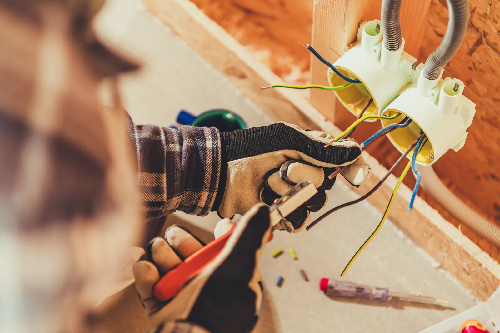 Electrician installing electrical outlet wiring in a home
